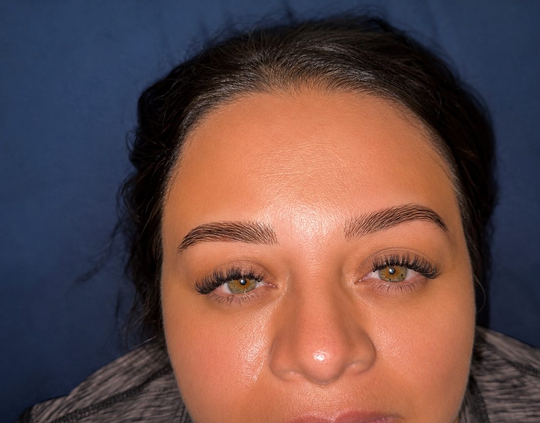 Close-up of soft, fluffy lash extensions on a client with hazel eyes